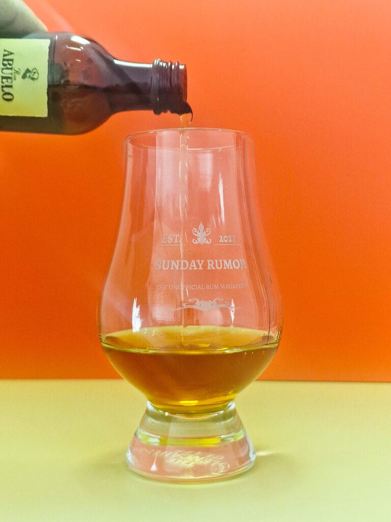 Ron Abuelo Añejo 7 pouring into glass. Whisky glass. Sunday rumor. Rum in glass